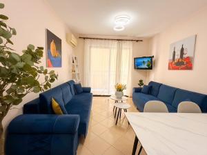 a living room with blue couches and a table at Bogdani Apartment in Golem