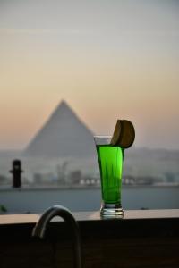 a green glass sitting on top of a table at Makan Pyramids View in Cairo