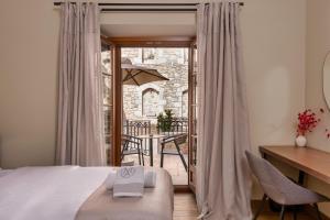 a bedroom with a bed and a desk and a balcony at Μikri Arktos Boutique Hotel in Dimitsana +96 photos