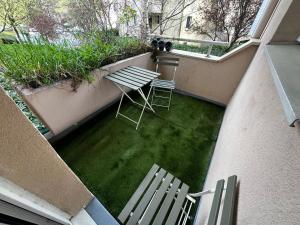 a patio with two chairs and a table and grass at Ulis très beau 2 pièces tout équipé in Les Ulis