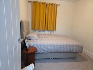 a small bedroom with a bed and a yellow curtain at HomeAway Comfort in Minster +11 photos