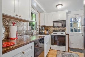 a kitchen with white cabinets and a wooden counter top at Charming Rowhome in Downtown Annapolis in Annapolis +12 photos