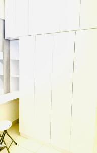 a room with white cabinets and a chair at Angelic stay in Hulhumale