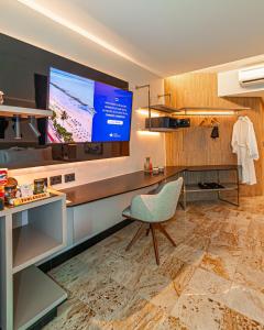 a room with a television and a chair in a room at Hotel Atlante Plaza in Recife