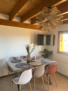 a dining room table with chairs and a chandelier at Cosy d'Asmae in Ustou