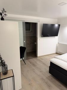 a bedroom with a bed and a tv in a room at Gaststätte und Hotel zur Krone in Pohlheim