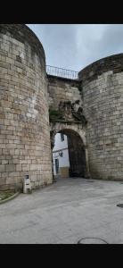 a large brick wall with an archway in a building at PASEO ROMANo in Lugo