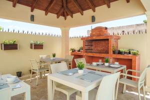a patio with tables and chairs and a brick oven at Beautiful Three Storage House Near Playa Caleta in La Romana