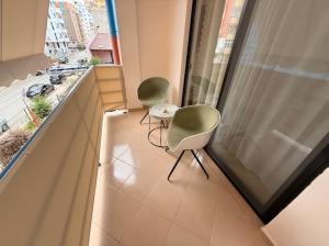 a balcony with two chairs and a window at Bogdani Apartment in Golem