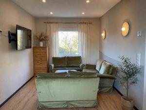 a living room with a couch and a window at Haus der alten Bäume - Retreathaus Hillesheim in Hillesheim