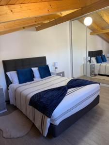 a bedroom with a large bed with blue pillows at Casa da Quinta in Estreito da Calheta