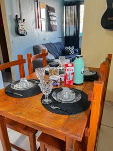 a wooden table with plates and wine glasses on it at 4 min do Paraguai Casa com piscina e privacidade in Foz do Iguaçu