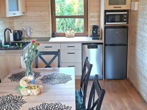a kitchen with a table and a refrigerator at Domek Bursztyn in Święta Katarzyna