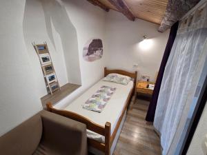 a small bedroom with a bed and a couch at Traditional Piran house in Piran