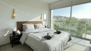 a bedroom with a large bed and a large window at Coralli Beachfront 1BDR Protaras in Paralimni +22 photos