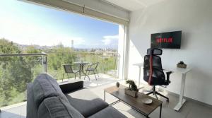 a living room with a couch and a large window at Coralli Beachfront 1BDR Protaras in Paralimni