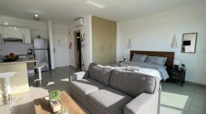 a living room with a couch and a bed at Coralli Beachfront 1BDR Protaras in Paralimni