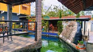 a pool at a resort with a rock in the water at Pousada H&D in Angra dos Reis
