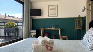 a bedroom with a bed and a large window at Vila Camélia in Porto