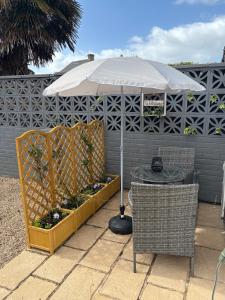 a table with an umbrella and two chairs and a table with at The Snug Guestroom Poole in Poole