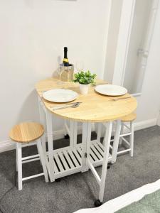 a wooden table with two chairs and a bottle of wine at The Snug Guestroom Poole in Poole