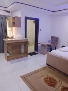 a bedroom with a bed and a table and a bathroom at Lynstel Apartment & Suites in Abuja