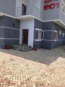a building with a brick courtyard in front of it at Lynstel Apartment & Suites in Abuja