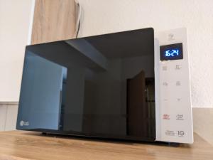 a microwave oven with a clock on top of it at K&K City-Apartment in Weimar +1 photo