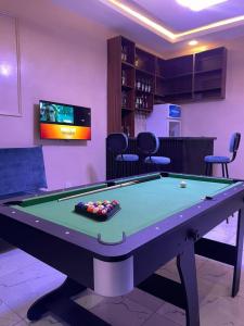 a pool table in a room with a tv at Lynstel Apartment & Suites in Abuja