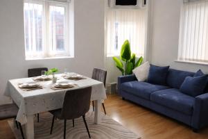 a living room with a table and a blue couch at City Centre stay in Liverpool +8 photos