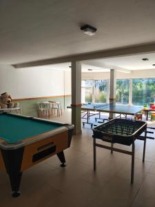 a billiard room with two pool tables and chairs at Amarras pinamar in Pinamar