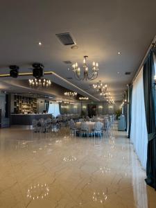 a banquet hall with tables and chairs and chandeliers at VIS Palm Hotel Ganja in Ganja