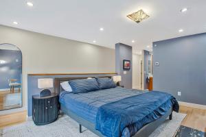 a bedroom with a large bed with a blue comforter at Luxe Row Home Steps to USNA Gate 3 in Annapolis