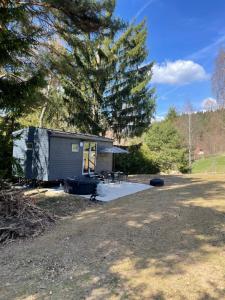 a small shed with a picnic table in a yard at maringotky Šumava in Dlouhá Ves