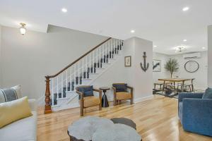 a living room with a couch and a staircase at Luxe Row Home Steps to USNA Gate 3 in Annapolis