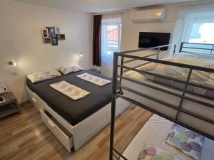 a bedroom with two bunk beds and a television at Traditional Piran house in Piran