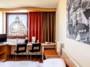 a hotel room with a desk and a window at Ibis Wien Mariahilf in Vienna +102 photos