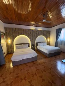 ein Schlafzimmer mit zwei Betten und einer Holzdecke in der Unterkunft Hotel Casa Bataneca in Comitán de Domínguez