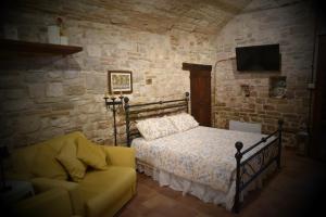 a bedroom with a bed and a couch at O rosa bella Appartamento via savelli della porta 24 in Gubbio