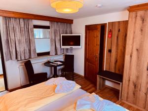 a bedroom with a bed and a table and a tv at König Ludwig Stub´n in Prien am Chiemsee