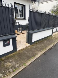 a black and white fence next to a house at The13th in Rueil-Malmaison