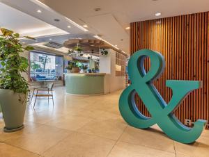 a large green x sign on a wall in a lobby at B&B HOTEL Rio Copacabana Forte in Rio de Janeiro +58 photos