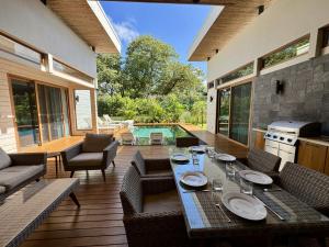 a dining table and chairs on a patio with a pool at Private Pool with direct access to 2 beaches! in Tamarindo