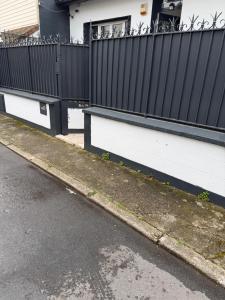 a black and white fence next to a street at The13th in Rueil-Malmaison
