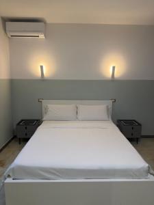ein Schlafzimmer mit einem großen weißen Bett und zwei Nachttischen in der Unterkunft HHBB hotel in Padua