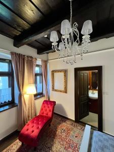 a red bench in a living room with a chandelier at Antik Vendégház in Nagyvisnyó