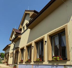 a building with windows and flowers on it at Nostalgia restaurant & pension in Rimavská Sobota