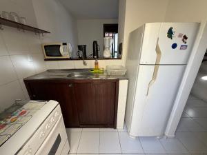 a kitchen with a white refrigerator and a sink at Mar Azul Flats com Piscina, Cozinha mais estacionamento em Ponta N in Natal