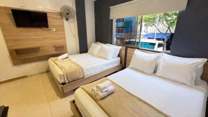 a hotel room with two beds and a television at HOTEL MEDELLIN CENTRAL in Medellín