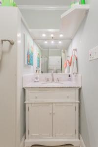 a white bathroom with a sink and a mirror at Creekside Paradise in Tybee Island +36 photos
